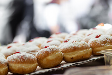 fried and stuffed sufganiot with strawberry jam, displayed for sale at the Mahane Yehuda market in...