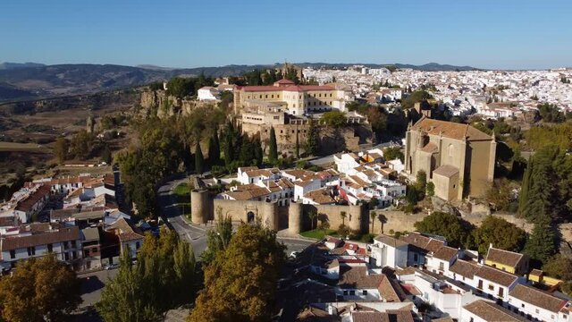 Aerial drone footage of the fortification at the entrance of the Ronda old town in Andalusia, Spain. Shot with a tilt down and rotation motion