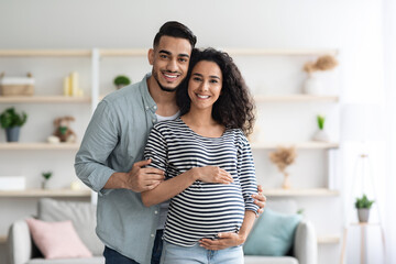 Happy arabic expecting family posing at home