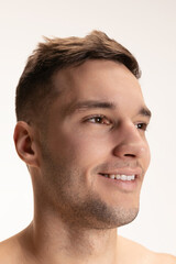 Fototapeta premium Close-up portrait of young happy handsome shirtless man looking away isolated on grey studio background.