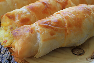 A pastry with potatoes inside, which is wrapped in a roll of pastry.
