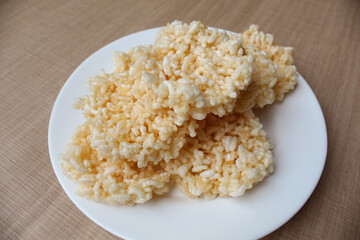 Rengginang, traditional crackers from Indonesia, made from sticky rice which dried then fried. On a white plate.