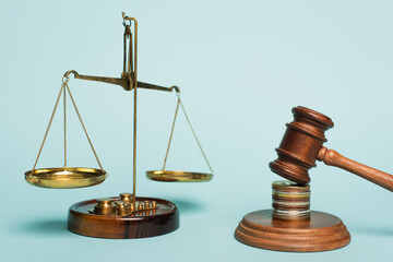 bronze justice scales, wooden gavel and coins on blue background, anti-corruption concept