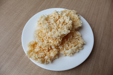 Rengginang, traditional crackers from Indonesia, made from sticky rice which dried then fried. On a white plate.