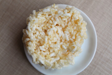 Rengginang, traditional crackers from Indonesia, made from sticky rice which dried then fried. On a white plate.