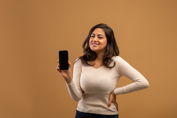 Happy young arab woman showing modern smartphone with blank screen, recommending mobile app or offer, mockup