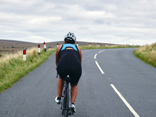 Fototapeta na wymiar Rear view of female cyclist on country road