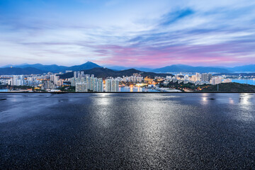 Fototapeta premium Asphalt road and modern city skyline with buildings at dusk