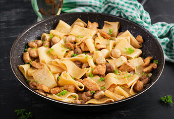 Pasta Calamarata with chicken meat, mushrooms and soy sauce. Italian cuisine.
