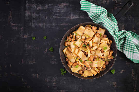 Pasta Calamarata with chicken meat, mushrooms and soy sauce. Italian cuisine. Top view, overhead