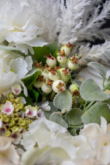 Plastic handmade bouquet artificial flowers composition.Beautiful flowers in vase on a table with black  background. Women's, mother's day. Spring, summer season. Front view.Selective focus.
