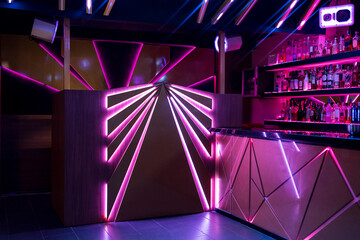 Illuminated night club with bar counter and shelves of alcohol drinks