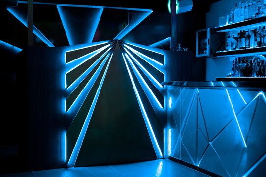 Illuminated night club with bar counter and shelves of alcohol drinks