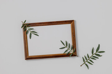 Empty brown wood border, with craft paper and green branches isolated on white table background.
