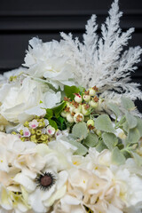 Plastic handmade bouquet artificial flowers composition.Beautiful flowers in vase on a table with black  background. Women's, mother's day. Spring, summer season. Front view.Selective focus.
