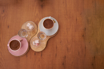 Cups of Traditional delicious Turkish coffee with glass of water and Turkish delight on the table.Cups of coffee in the morning on wooden table with fortune letter.Romantic date in cafe with coffee.