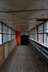 Corridor in an old building with shabby wooden floor and old windows with wooden frame