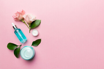 Composition with cosmetic products and beautiful roses on color background. Copy space, flat lay