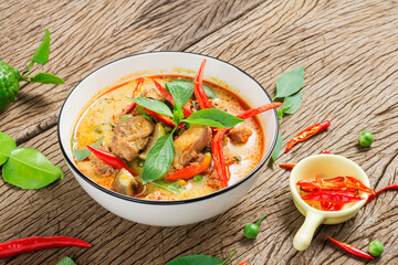 Thai food, green curry or red curry with chicken on the wooden floor, top view