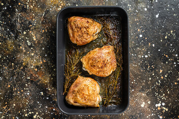 Oven Roasted chicken thighs with spices in baking dish. Brown background. Top View