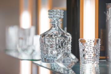 Glass crystal whiskey bottle with glasses in the forground