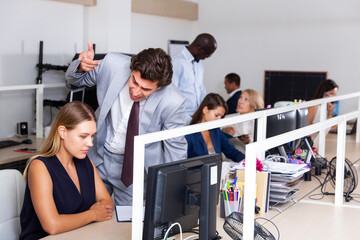Fototapeta premium Irritated young boss scolding unhappy female subordinate pointing out shortcomings and misses in work