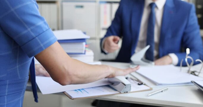 Secretary staples document and transfers it to colleagues for storage in folder