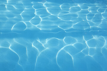 Water background. Blue swimming pool pattern with natural rippled water texture and horizontal shade. Top view