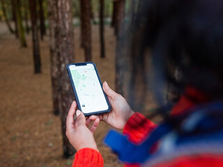 Female hiker using map on smart phone