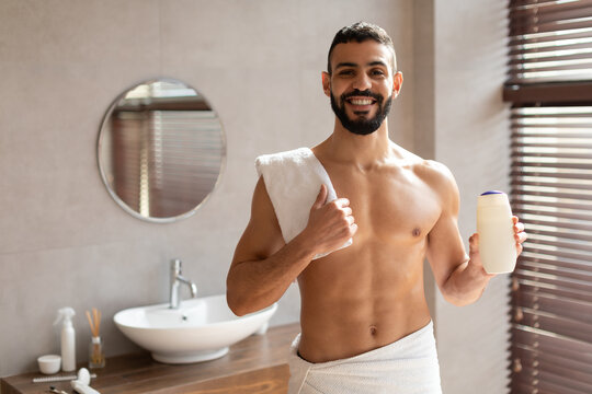 Handsome Young Guy Standing With Shampoo Bottle In Hands