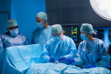 Multiracial team of professional medical surgeons performs the surgical operation in a modern hospital. Doctors are working to save the patient. Medicine, health, cardiology and transplantation.