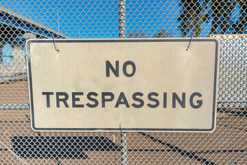 No trespassing sign on a mesh wire fence at Coronado, San Diego, California - obrazy, fototapety, plakaty