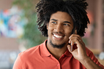 Phone Call. Closeup Of Smiling Millennial Black Man Talking On Cellphone Indoors