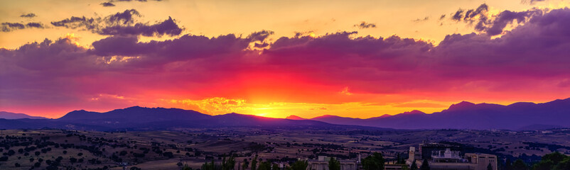 Panoramic of golden sunset over the mountains and wooded fields of the north of Madrid in the Sierra de Guadarrama Spain.