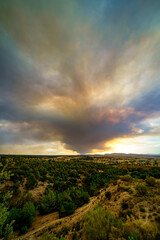 Large column of smoke over the sky from a forest fire in the mountains of Madrid Spain.