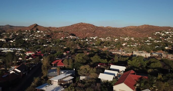 4K aerial Windhoek capital residential central hilly district bright sunset drone video with upmarket houses and old white walls German mansion on top of hill in Khomas Region, central Namibia