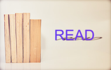 stack of books arranged horizontally on white background blur read word