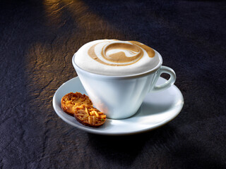 Cappuccino mit Florentiner auf warmen Granituntergrund