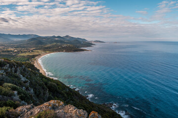Fototapeta na wymiar View over Losari beach and the turquoise Mediterranean sea in the Balagne region of Corsica with Ile Rousse in the distance