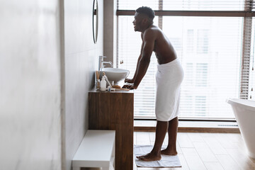 Happy African American Man Standing Near Mirrorn In Modern Bathroom