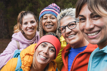 Happy multiracial women taking a selfie during trekking day - Multi generational friendship