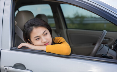 Young asian woman has broken down car on the road she feeling serious and stressed.Look for someone help. Call Emergency assistance or insurance service.