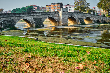 Abdal bridge of made by ottoman empire and stone material. city and local houses background.