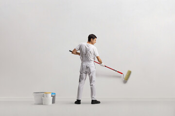 Rear view shot of a house painter painting a wall