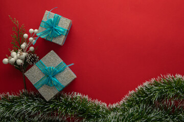 Christmas background with gift boxes with blue bow, green branches and red background
