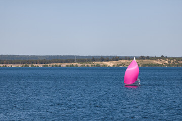 A boat with scarlet sails floats on the river