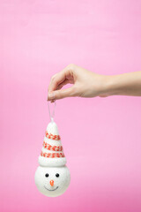 beautiful head of a snowman with a hat in hand. Pink background. New Year's and Christmas idea. holidays
