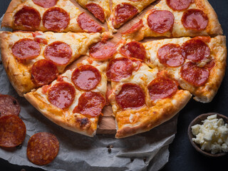 Pepperoni pizza with sausage on a dark background.