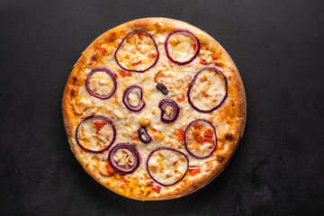 Delicious homemade pizza topped with red onion rings. 