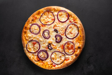 Delicious homemade pizza topped with red onion rings. 